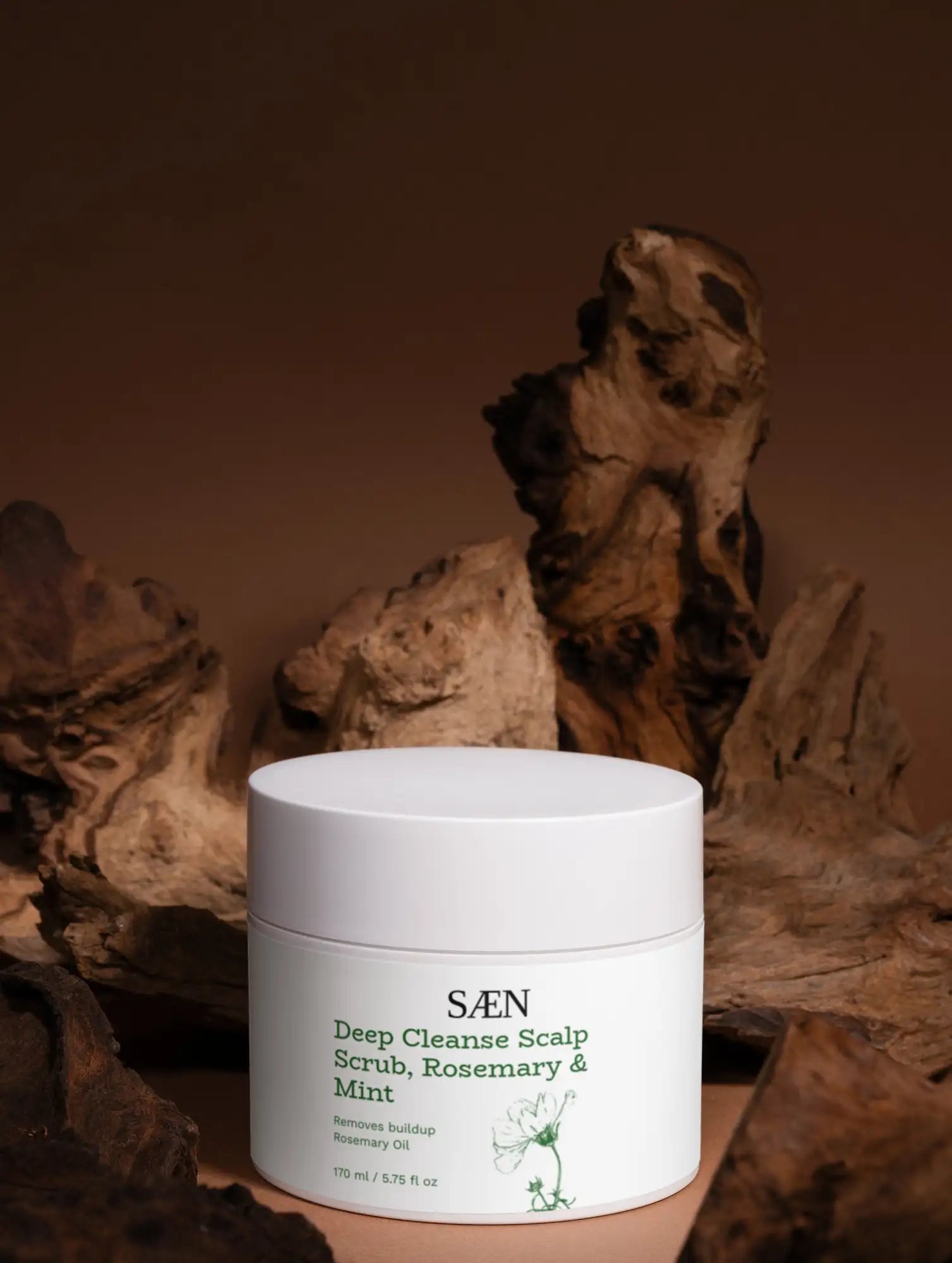 White cylindrical jar of saen deep cleanse scalp scrub, rosemary & mint, featuring minimalist labeling with green text and a small botanical illustration.